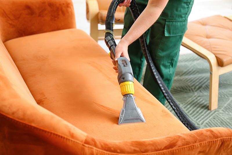 dry-cleaner-s-employee-removing-dirt-from-sofa-house